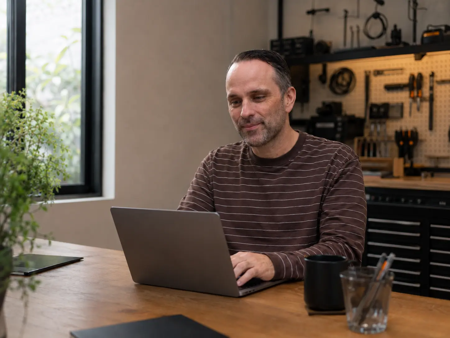 Joel at a working desk with a whiteboard of system diagrams behind him